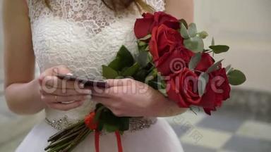 穿着婚纱的年轻新娘在室内捧着花束。 白色豪华礼服